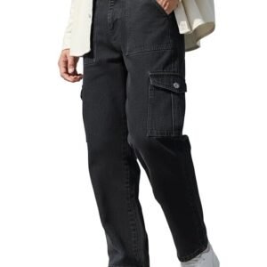 A side-view profile of a person wearing dark indigo, straight-leg denim cargo pants featuring large front patch pockets and button-down side cargo pockets, paired with white sneakers.