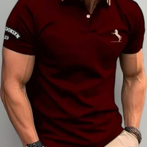 Front view of a man wearing a deep maroon slim-fit polo shirt featuring a small white horse embroidery on the chest, striped collar detailing, and "Brooklyn" sleeve branding, paired with khaki trousers.