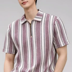 Front-facing view of a man wearing a short-sleeved knit polo shirt with vertical stripes in dusty rose and cream, featuring a bronze quarter-zip neckline and paired with off-white trousers.