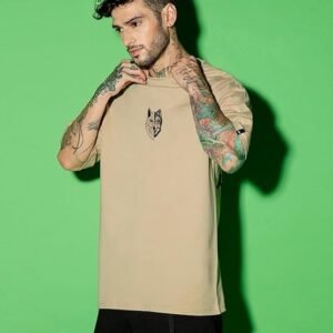 A rear three-quarter view of a person wearing loose-fitting, dark indigo denim cargo pants featuring a large back pocket and faded detailing on the legs.