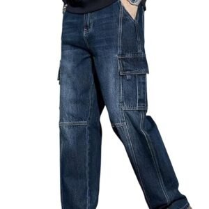 A full-length shot of a person wearing relaxed-fit, dark-wash denim cargo pants with panelled stitching and utility pockets, paired with white sneakers.